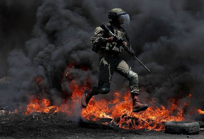 An Israeli border police member jumps during a Palestinian protest against Israel's plan to annex parts of the Israeli-occupied West Bank, in Kafr Qaddum near Nablus on July 3, 2020. (Photo by Mohamad Torokman/Reuters)